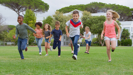 Wall Mural - Group Of Children Playing Having Fun Running  Across Park With Friends