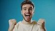 © DruZhi Art - Overjoyed Young Man Celebrating Win with Raised Hands and Happy Expression on Blue Background