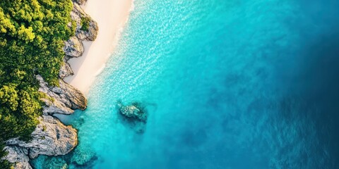 Wall Mural - aerial view of a serene beach with clear turquoise water, rocky coastline, and lush green vegetation