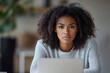 © James - Upset young african american woman with curly hair looking for a job online, sitting at a desk, using a laptop, no job opportunity, feeling depressed, Generative AI