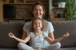 © Digi ART - Cute little girl with young mother sitting in lotus pose on couch at home, mum and daughter practicing yoga and laughing, having fun on weekend, Generative AI