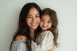© Digi ART - Happy woman mother hugging her pretty little daughter and smiling together at camera over white wall, full length shot, Generative AI