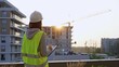 © volha_r - Construction female engineer taking notes and writing on clipboard while inspecting a building site at sunset. Industry development concept