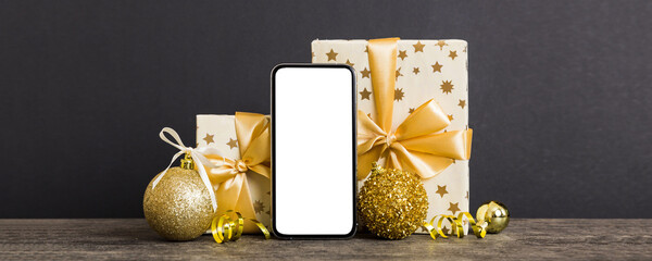Digital phone mock up with rustic Christmas decorations for app presentation with empty space for you design. Christmas online shopping concept. Tablet with copy space on colored background