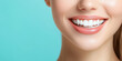 © Maksym - The bright, joyful expression of a womanâs close-up smile with flawless white teeth, framed by a soft, blurred blue background, symbolizing health, beauty, and dental confidence.