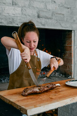 Wall Mural - Smiling woman with light eyes, cutting meat