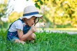 © yanadjan - A child looks through a magnifying glass in nature. Selective focus.