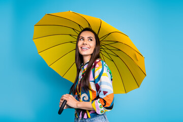 Photo of toothy beaming nice woman wear print shirt jeans holding umbrella look at offer empty space isolated on blue color background