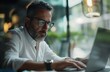 © irabublikova - mature man with glasses working on a laptop.
