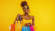 © LordTonGz - A cheerful young African American woman strikes a playful pose against a bold yellow background, exuding confidence and joy. Dressed in trendy summer attire with stylish sunglasses.