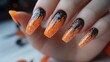© Alief Shop - Hand adorned with long orange artificial nails featuring Halloween-themed nail art