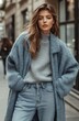 © olegganko - Stylish young woman wearing a cozy sweater and oversized coat in a city street on a chilly day