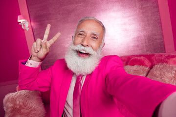 Canvas Print - Photo of excited mature grandfather sit sofa couch make v sign wear pink color blazer in room interior