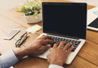 © Prostock-studio - Unrecognizable african-american businessman working on laptop in modern office, side view, copy space