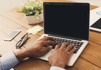 Poster - Unrecognizable african-american businessman working on laptop in modern office, side view, copy space