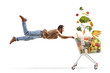 © Ljupco Smokovski - Casual man flying and holding a shopping cart filled with flying  food products