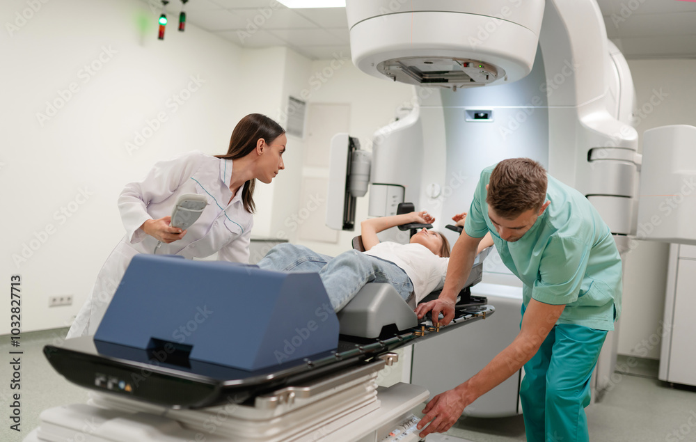 Two healthcare professionals prepare patient for radiotherapy treatment ...