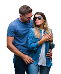 Wall Mural - Young couple in love wearing sunglasses over isolated background smiling with hands on chest with closed eyes and grateful gesture on face. Health concept.