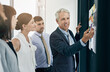 © ThurstanJam/peopleimages.com - Presentation, sticky note and team of business people in training, brainstorming or risk management analysis. Strategy, group and writing solution on glass wall, data and happy ceo coaching in office