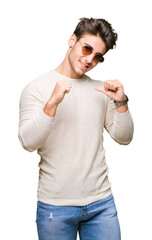 Wall Mural - Young handsome man wearing sunglasses over isolated background looking confident with smile on face, pointing oneself with fingers proud and happy.