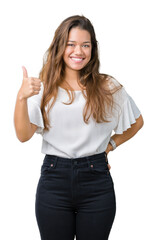 Sticker - Young beautiful brunette business woman over isolated background doing happy thumbs up gesture with hand. Approving expression looking at the camera showing success.