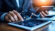 © JK_kyoto - A businessman analyzes data on a tablet while using a smartphone, showcasing digital technology in finance.