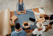 © KayExam/peopleimages.com - Above, business and people with boxes for fashion distribution, ecommerce delivery and packing clothes. Employees, online shopping and cardboard for fabric sale, manufacturing industry and production