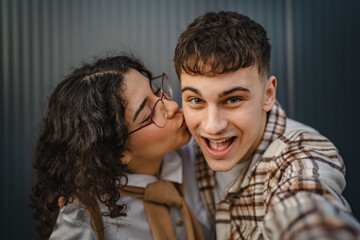 self portrait of girlfriend who kiss boyfriend in front black wall