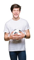 Wall Mural - Young man holding soccer football ball over isolated background with a happy face standing and smiling with a confident smile showing teeth