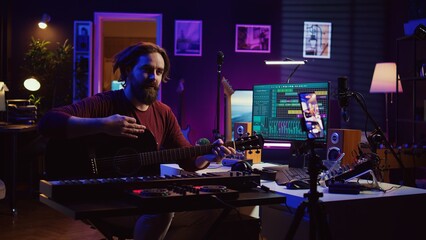 Poster - Guitarist instructor teaching guitar lessons online on internet, recording video on smartphone as a tutorial. Singer explaining acoustic instrument techniques, gives musical assistance. Camera B.