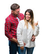 © Krakenimages.com - Young couple in love wearing winter sweater over isolated background smiling with happy face looking and pointing to the side with thumb up.