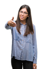 Wall Mural - Young beautiful hispanic business woman smiling friendly offering handshake as greeting and welcoming. Successful business.