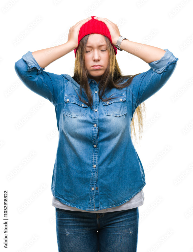 Young caucasian beautiful woman wearing wool cap over isolated background suffering from headache desperate and stressed because pain and migraine. Hands on head.
