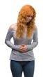 © Krakenimages.com - Young redhead woman with hand on stomach because nausea, painful disease feeling unwell. Ache concept.