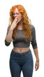 © Krakenimages.com - Young redhead woman bored yawning tired covering mouth with hand. Restless and sleepiness.