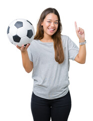 Sticker - Young beautiful brunette woman holding soccer football ball over isolated background surprised with an idea or question pointing finger with happy face, number one