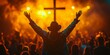 © inspiretta - A man in a cowboy hat is holding a cross and is surrounded by a crowd of people. Concept of unity and celebration, as the man and the crowd are all raised in a gesture of worship