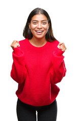 Wall Mural - Young beautiful arab woman wearing winter sweater over isolated background celebrating surprised and amazed for success with arms raised and open eyes. Winner concept.