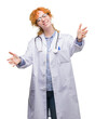 © Krakenimages.com - Young redhead woman wearing doctor uniform looking at the camera smiling with open arms for hug. Cheerful expression embracing happiness.