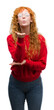 © Krakenimages.com - Young redhead woman wearing red sweater looking at the camera blowing a kiss with hand on air being lovely and sexy. Love expression.