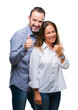 © Krakenimages.com - Middle age hispanic business couple over isolated background doing happy thumbs up gesture with hand. Approving expression looking at the camera with showing success.