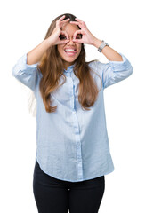 Wall Mural - Young beautiful brunette business woman over isolated background doing ok gesture like binoculars sticking tongue out, eyes looking through fingers. Crazy expression.