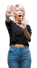 Wall Mural - Young beautiful blonde woman over isolated background afraid and terrified with fear expression stop gesture with hands, shouting in shock. Panic concept.