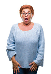 Wall Mural - Atrractive senior caucasian redhead woman wearing glasses over isolated background afraid and shocked with surprise expression, fear and excited face.