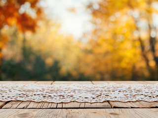 Poster - Empty wooden table with lace tablecloth over autumn background