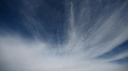 Wall Mural - time lapse of white clouds moving across a dark blue sky. only sky in frame