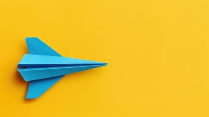 Canvas Print - A vibrant blue origami plane stands out against a bright yellow backdrop, symbolizing freedom and creativity in paper art.