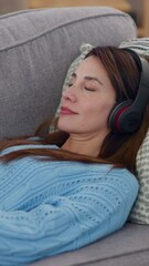 Sticker - Mature, woman and relax with headphones on sofa for listening to music, radio app and audio playlist in home. Person, dancing and rest on couch in lounge for streaming subscription and favorite song