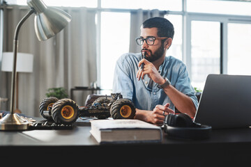 Aufkleber - Laptop, robotics and thinking with engineer man in home office for invention or remote work. Car, idea and model with male person on computer in apartment for problem solving or vehicle design