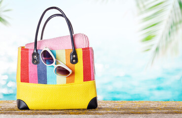 Poster - A beach bag with towels and sunglasses placed on a table